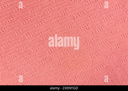 Texture and pattern of a knitted pink wool sweater. Background of warm handmade wool fabric. Stock Photo