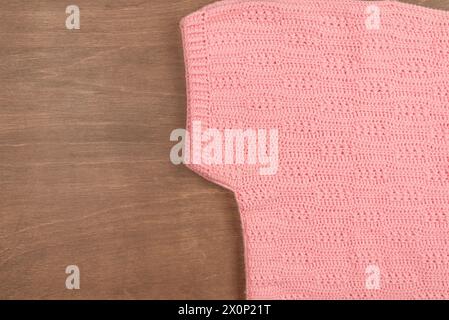 Warm winter knitted pink wool sweater on a wooden background Stock Photo