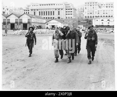 Italian prisoners, escorted by British troops, carry their wounded ...