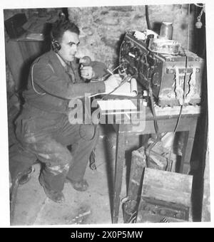 FIFTH ARMY : SPOTTING THE ENEMY GUNS - L/Bdr. F.W. Howarth of Hull operates the wireless set which is used by the Listening Post in the event of the telephone cable being out of commission. This unit are the only occupants of the village of Rioveggio, which is heavily shelled and mortared by the enemy. Photographic negative , British Army Stock Photo