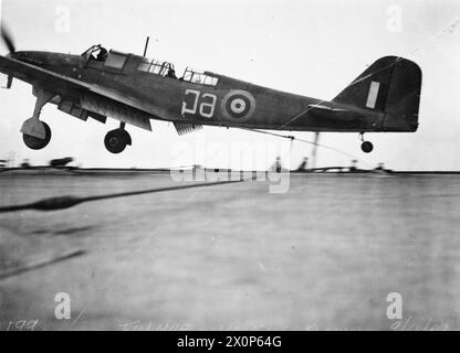 ON BOARD HMS VICTORIOUS. 29 MARCH TO 9 APRIL 1942, ON BOARD THE AIRCRAFT CARRIER IN HARBOUR AT SCAPA AND DURING FLYING EXERCISES OFF HOY. - A Fairey Fulmar of 809 Squadron landing on the flight deck of HMS VICTORIOUS with its hook down Stock Photo