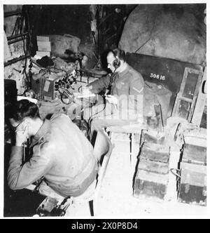 FIFTH ARMY : SPOTTING THE ENEMY GUNS - Gnr. F. Cullingworth (foreground) of Sheffield 10, in charge of the recorder, and L/Bdr. H.A. King of Beckenham, who operates the wireless set in communication with the Listening Post. Photographic negative , British Army Stock Photo