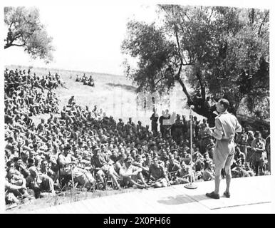 GEORGE FORMBY IN ITALY - George Formby entertaining the troops, the Eighth Army Commander is seen seated in the chair in front of his men. Photographic negative , British Army Stock Photo