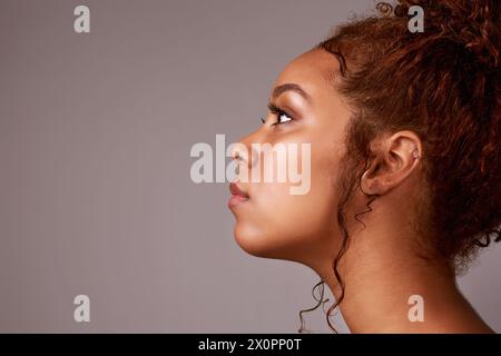 Skincare, mockup and girl thinking in studio with cosmetics, questions or tips on grey background. Beauty, face and model with space for dermatology Stock Photo