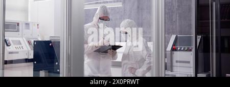 Engineer in clean factory room using tablet in laboratory Stock Photo