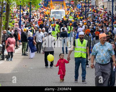 Gravesend, Kent, UK. 13th April. The town's large Sikh community celebrates Vaisakhi with a procession around the town starting and finishing at the Guru Nanak Darbar Gurdwara temple. The crowds enter the main street New Road Stock Photo