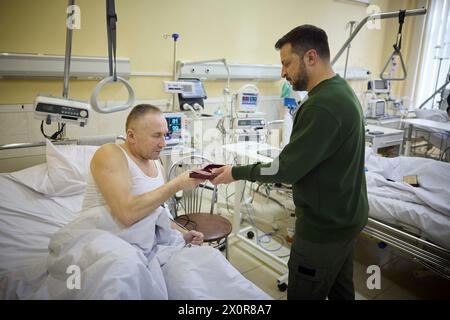 Chernivtsi, Ukraine. 12th Apr, 2024. Ukrainian President Volodymyr Zelenskyy, right, awards a state medal to a wounded soldier during a visit to a Military Hospital in the Donetsk region, April 12, 2023 in Chernivtsi, Chernivtsi Oblast, Ukraine. Credit: Handout/Ukrainian Presidential Press Office/Alamy Live News Stock Photo