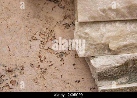 Natural wooden painted cork surface and beautiful beige structural stone wall consists of small bricks for interior design. Stock Photo