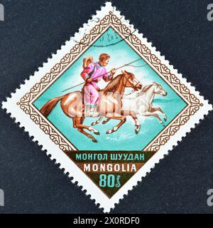 Cancelled postage stamp printed by Mongolia, that shows Capture of wild horses,  National Naadam celebration, circa 1974. Stock Photo