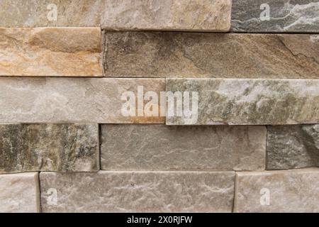 Beautiful beige structural stone wall of the ancient building consists of small bricks. Stock Photo