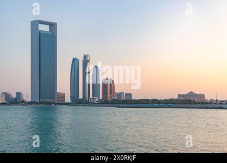 A picture of the Etihad Towers, the Abu Dhabi National Oil Company Headquarters and the Emirates Palace Mandarin Oriental Hotel at sunset. Stock Photo