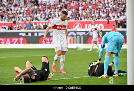 13 April 2024, Baden-Württemberg, Stuttgart: Soccer: Bundesliga, VfB Stuttgart - Eintracht Frankfurt, Matchday 29, MHPArena. Robin Koch (l) and Ansgar Knauff (r) from Eintracht Frankfurt lie on the ground after a duel. Stuttgart's Deniz Undav stands next to them. Goalkeeper Kevin Trapp of Eintracht Frankfurt is on the right. Photo: Jan-Philipp Strobel/dpa - IMPORTANT NOTE: In accordance with the regulations of the DFL German Football League and the DFB German Football Association, it is prohibited to utilize or have utilized photographs taken in the stadium and/or of the match in the form of s Stock Photo