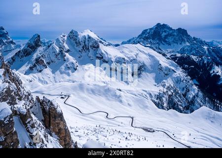 Aerial view on the snow-covered Giau pass from Mt. Nuvolau in winter, the snow-covered summits of Mt. Cernera and Mt. Civetta in the distance. Cortina Stock Photo