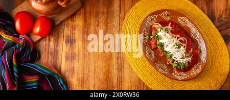 Entomatadas. Also known as Enjitomatadas, a typical dish of Mexican cuisine prepared with corn tortilla, tomato sauce and stuffed with shredded chicke Stock Photo