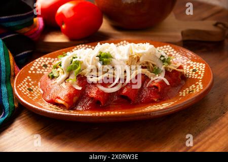 Entomatadas. Also known as Enjitomatadas, a typical dish of Mexican cuisine prepared with corn tortilla, tomato sauce and stuffed with shredded chicke Stock Photo