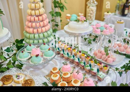 Macaron tower or pyramid and cupcakes on sweet dessert table Stock Photo