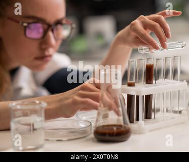 Caucasian woman in a medical gown doing laboratory experiments.  Stock Photo