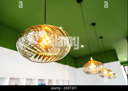 Opaline Glass Ornate Ceiling Lighting in a Cafe with green ceiling Stock Photo