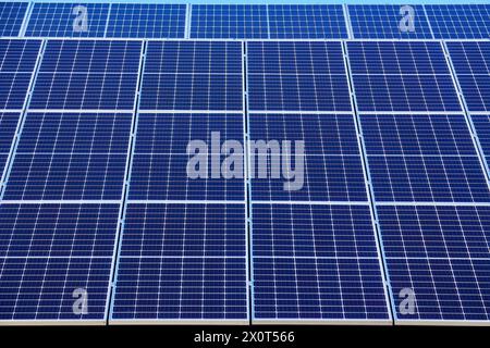Solar panels on small wood board domestic house roof, sustainable energy concept. Lot of copy space on clear blue sky. Stock Photo