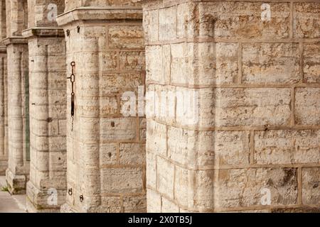 Old brick wall with arches. Weathered surface of the wall. Grunge style brick wall background. Weathered facade of a building. Horizontal. Stock Photo