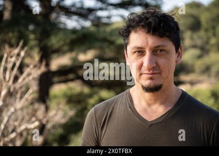 Close-up portrait of middle-aged caucasian man with a gaze and slight smile outdoors. Stock Photo