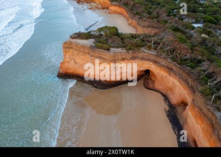 Aerial view of coastal cliff protruding out over a sandy beach at Anglesea on the Great Ocean Road in Victoria, Australia Stock Photo