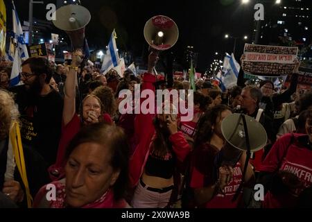 Tel Aviv, Israel. 16th Mar, 2024. Members of the activist group Pink Front yell into their megaphones. Two protests merge outside the Kirya military headquarters in Tel Aviv. One called for immediate elections to oust Netanyahu, the other calling for the release of the hostages still being held by Hamas. (Credit Image: © Syndi Pilar/SOPA Images via ZUMA Press Wire) EDITORIAL USAGE ONLY! Not for Commercial USAGE! Stock Photo