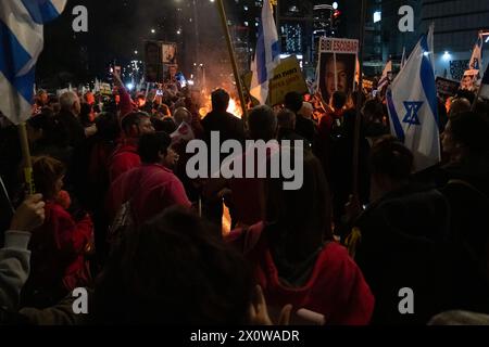 Tel Aviv, Israel. 16th Mar, 2024. Protesters around a bonfire holding Israeli flags and protest signs. Two protests merge outside the Kirya military headquarters in Tel Aviv. One called for immediate elections to oust Netanyahu, the other calling for the release of the hostages still being held by Hamas. (Credit Image: © Syndi Pilar/SOPA Images via ZUMA Press Wire) EDITORIAL USAGE ONLY! Not for Commercial USAGE! Stock Photo