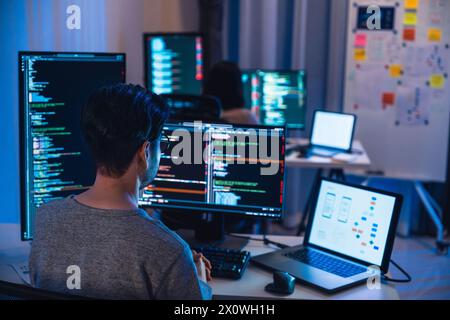 asian and Indian Developer  devops team working  about coding promgram with software computer at night in office Stock Photo