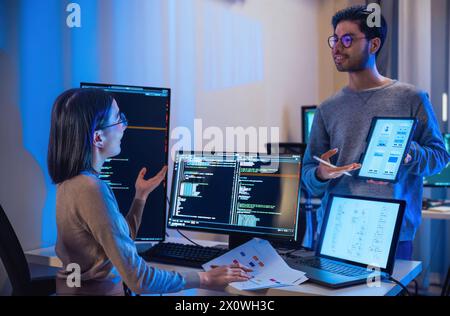 asian and Indian Developer  devops team discussion  about coding promgram with software computer at night in office Stock Photo