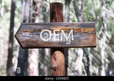 OEM original equipment manufacturer concept. Text on a wooden signpost against a forest background Stock Photo