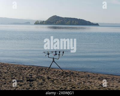 Island on Lake Bolsena near the town of Marta with fishing rods on a volcanic sandy beach, Viterbo province, Lazio Region, Italy. April13, 2024 Stock Photo