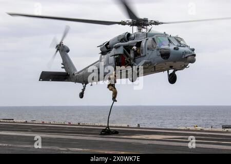 240413-N-MC925-2152 PACIFIC OCEAN (April 13, 2024) Sailors from Explosive Ordnance Mobile Unit 11 repel from an MH-60S Seahawk helicopter, assigned to Stock Photo