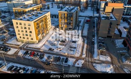 Drone photography of a few multistory house and parking lot covered by snow during winter sunny day Stock Photo