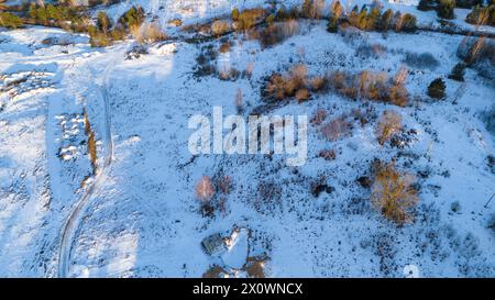 Drone photography of rural road covered by snow during winter sunny day Stock Photo
