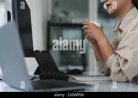Developer programmer drinking coffee and checking code on monitor for programming to developing web. Stock Photo