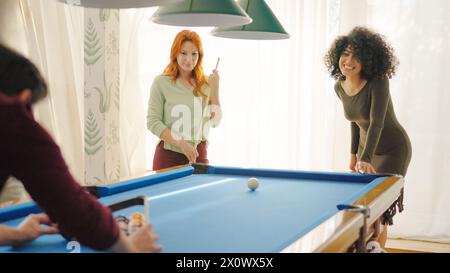 Group of diverse friends playing billiards in apartment Stock Photo