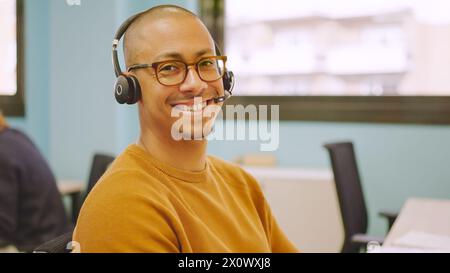 Smiling man using headset while working in a coworking Stock Photo