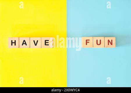 Have fun reminder wooden blocks typography in bright blue and yellow background. Stock Photo