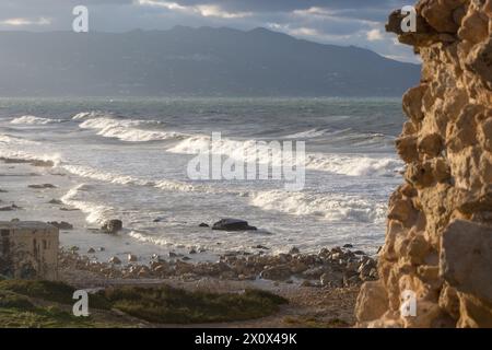 Windy day at the beach. Big waves. view from a rocky spot above tha beach. Mountains in the backround. Stock Photo