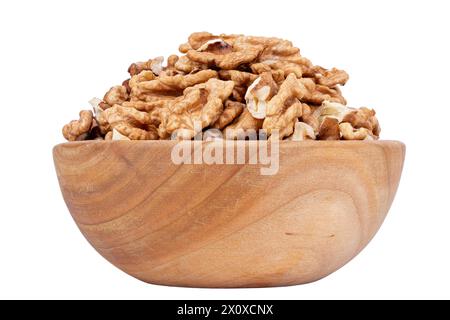 Walnut kernel halves, in wooden bowl isolated on white background. Shelled, dried seeds of the common walnut tree Juglans regia, used as snack or for Stock Photo