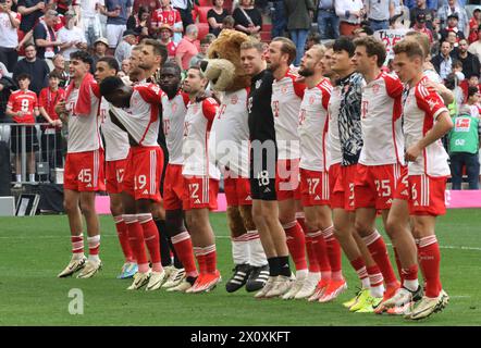 MUNICH, Germany - 13. April 2024: Die Bayern - Spieler feiern mit den Fans den Sieg vor der Suedkurve, Celebration of fans with the players Aleksandar Pavlovic (FC Bayern Muenchen), Jamal Musiala (FC Bayern Muenchen), Eric Dier (FC Bayern Munechen), Sven Ulreich (FC Bayern Muenchen), Alphons Davies (FC Bayern Muenchen), Dayot Upamecano (FC Bayern Muenchen), Raphael Guerreiro (FC Bayern Muenchen), #Berni, Daniel Peretz (FC Bayern Muenchen), Harry Kane (FC Bayern Muenchen), Konrad Laimer (FC Bayern Muenchen), Leon Goretzka (FC Bayern Muenchen), Noussair Mazraoui during the Bundesliga Football m Stock Photo