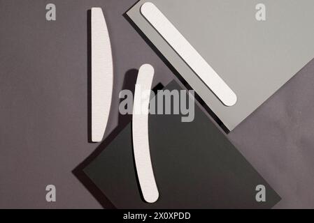 Set of gray nail files of different shapes and different stiffness on dark grey background, isometric. Tools for manicure Stock Photo