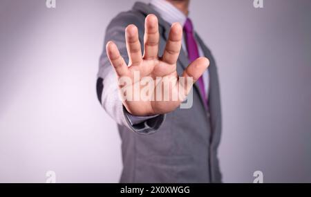 businessman shows stop sign, holding hand in the air. White background Stock Photo