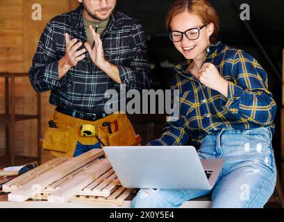 Young adult couple celebrating success of their startup. Stock Photo