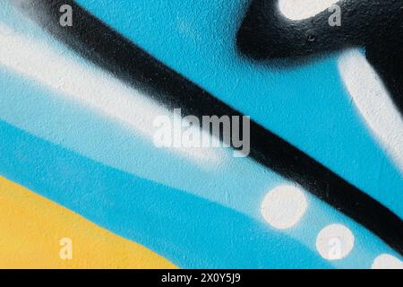 Fragment of old plaster wall with graffiti painting. Part of colorful street art graffiti on wall background. Youth, urban culture. Black, light blue Stock Photo