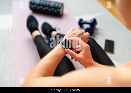 Sporty woman setting workout program using her smartwatch. Fitness trackers. Wearable technology Stock Photo