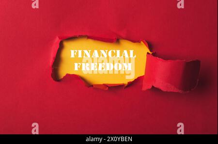 A red background with a hole in it and the words financial freedom written in white. Concept of openness and possibility Stock Photo