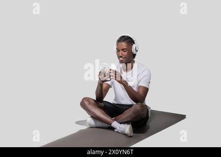 Young man smiling using smartphone and headphones Stock Photo
