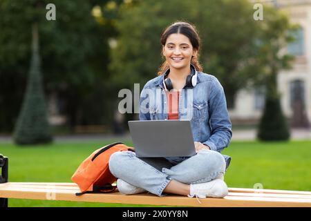 Relaxed woman student studying outdoors with laptop Stock Photo